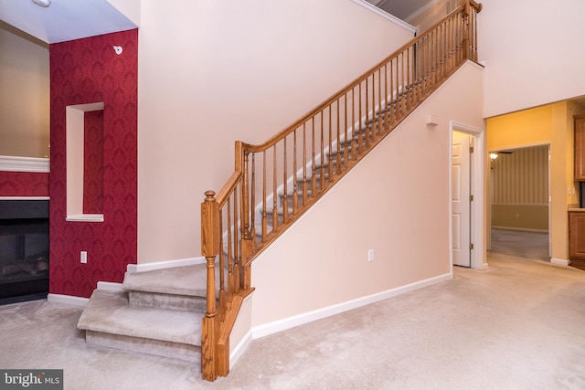 stairs featuring carpet flooring and a towering ceiling