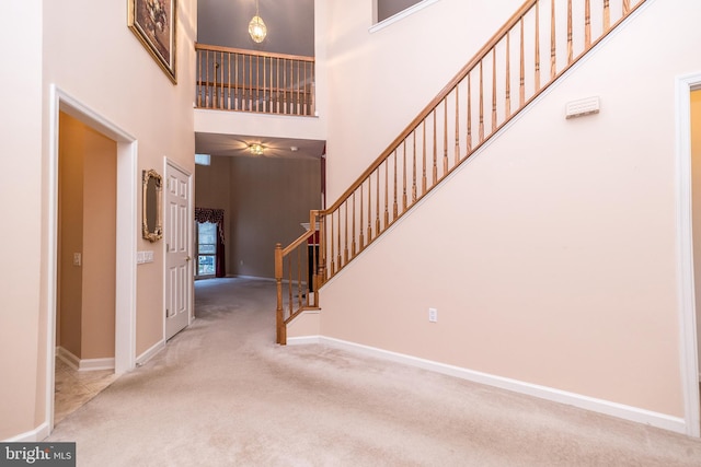 carpeted foyer with a high ceiling