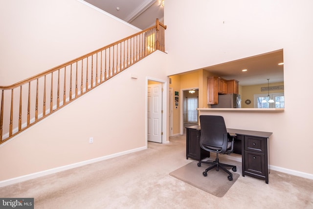 home office featuring a towering ceiling, light colored carpet, and ornamental molding