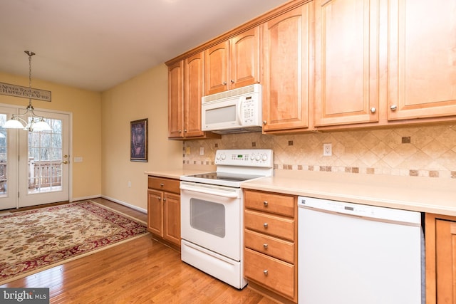 kitchen featuring white appliances, an inviting chandelier, tasteful backsplash, decorative light fixtures, and light hardwood / wood-style floors