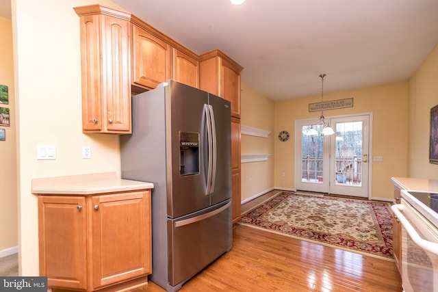 kitchen featuring stainless steel refrigerator with ice dispenser, decorative light fixtures, an inviting chandelier, white electric range, and light hardwood / wood-style floors