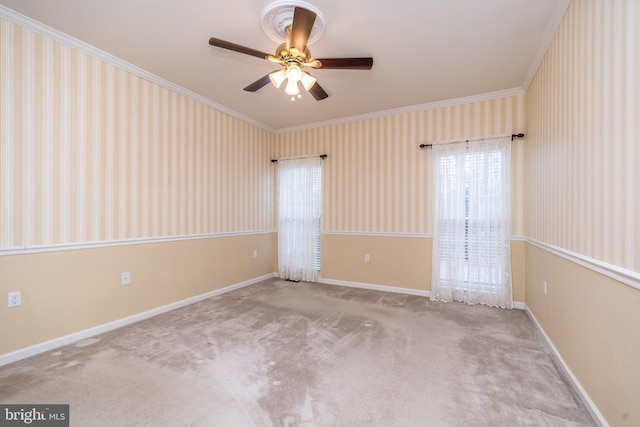 spare room with light colored carpet, ceiling fan, and crown molding