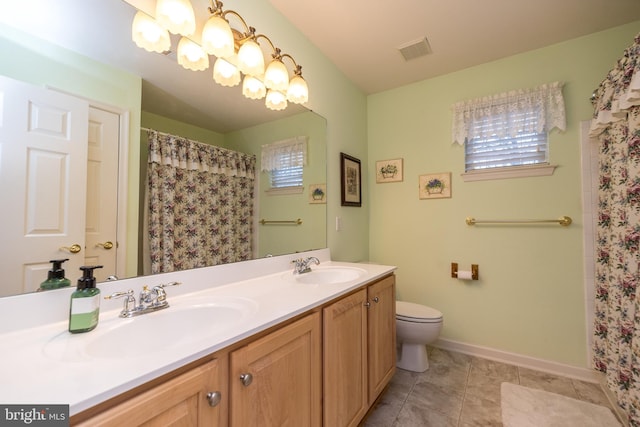 bathroom with tile patterned flooring, vanity, curtained shower, and toilet