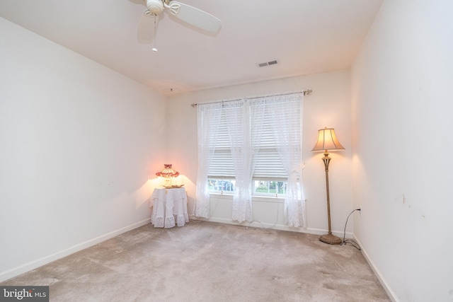 spare room with light colored carpet and ceiling fan