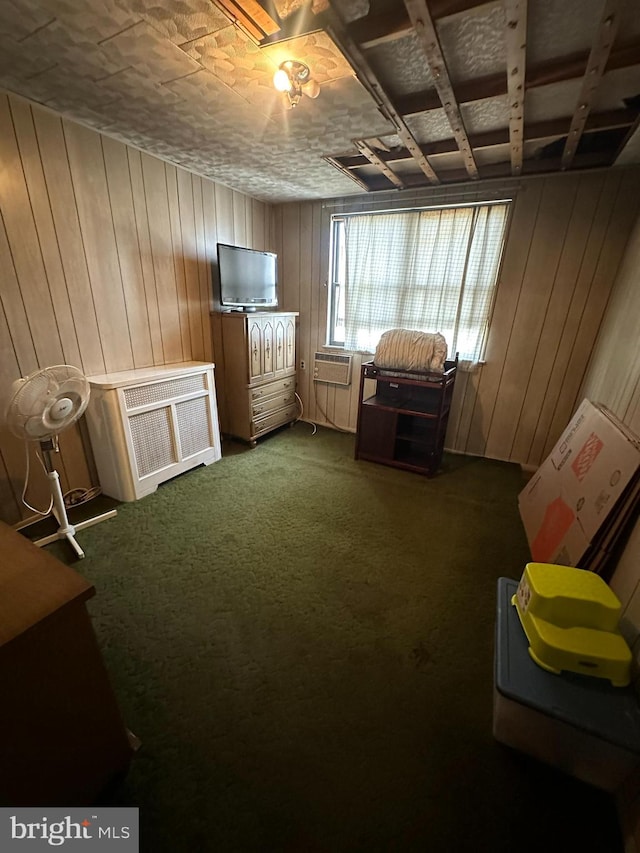 miscellaneous room featuring wooden walls and dark colored carpet