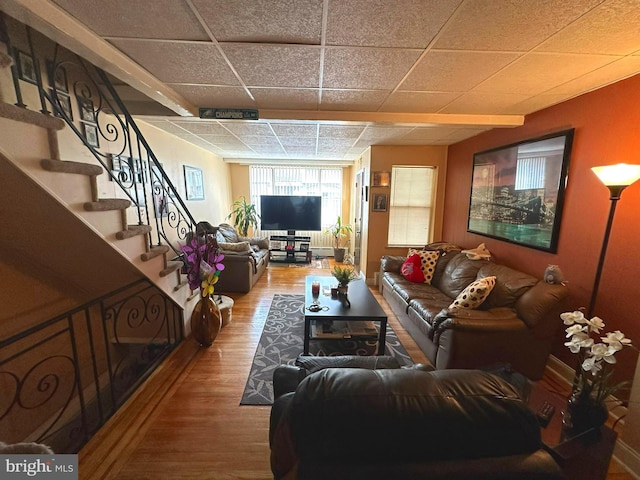 living room featuring a paneled ceiling and wood-type flooring