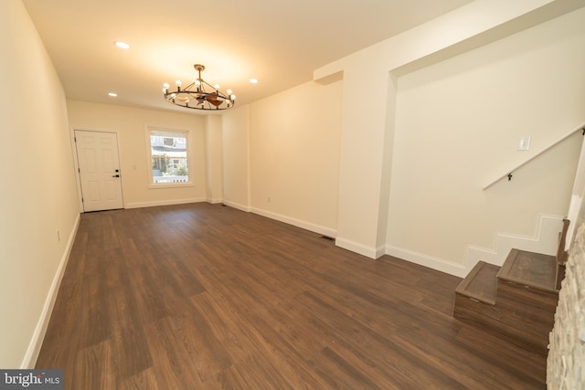 entrance foyer with dark hardwood / wood-style flooring and a notable chandelier