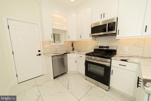 kitchen featuring white cabinetry, decorative backsplash, stainless steel appliances, and sink