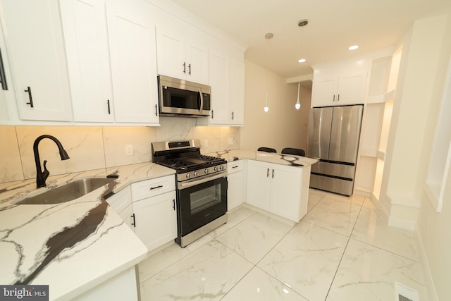 kitchen featuring sink, light stone countertops, pendant lighting, appliances with stainless steel finishes, and white cabinetry