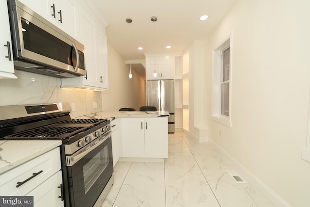 kitchen with white cabinets, kitchen peninsula, stainless steel appliances, and hanging light fixtures