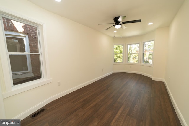 spare room with dark wood-type flooring and ceiling fan