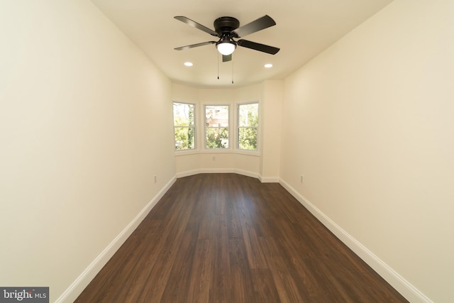 unfurnished room with ceiling fan and dark hardwood / wood-style flooring