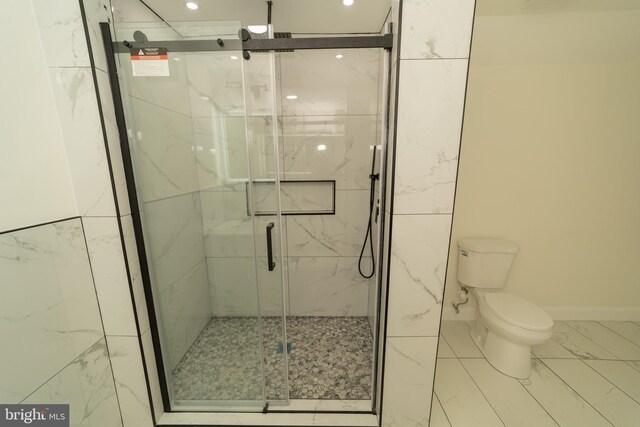 bathroom with toilet and a shower with shower door