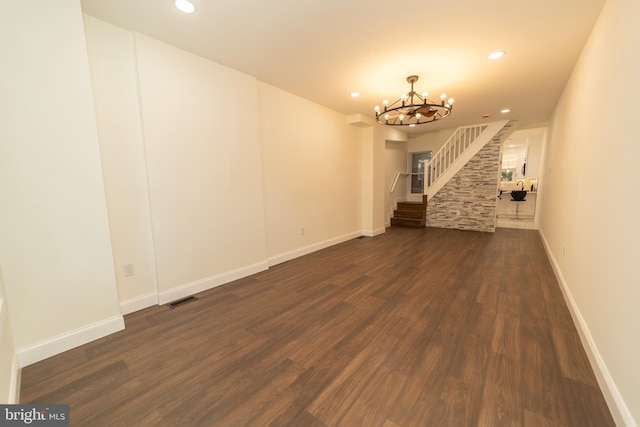 unfurnished living room with dark hardwood / wood-style floors and a chandelier