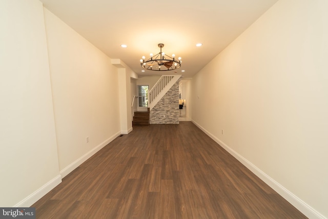 hallway with dark hardwood / wood-style flooring and a chandelier