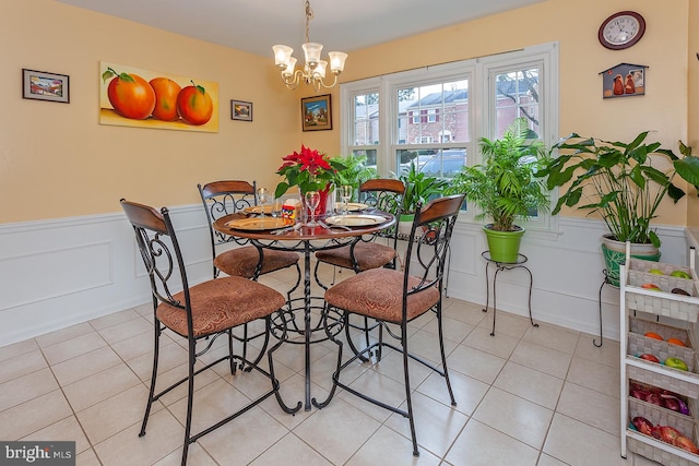 tiled dining room with a chandelier