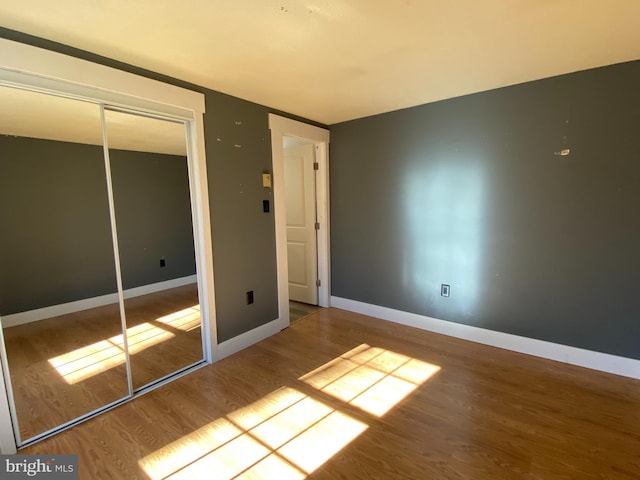 unfurnished bedroom featuring wood-type flooring and a closet