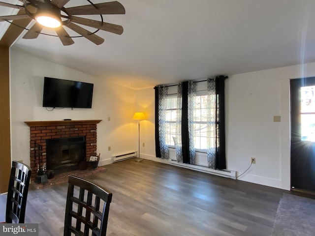 living room featuring baseboard heating, plenty of natural light, and wood-type flooring