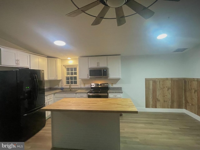 kitchen featuring black appliances, wood counters, white cabinets, and light wood-type flooring