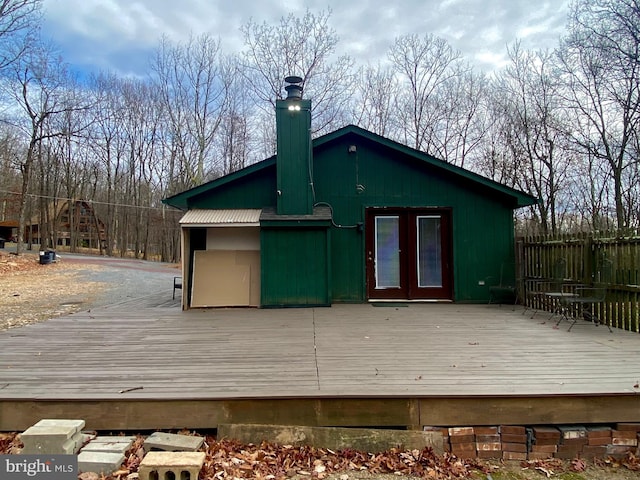 back of house featuring a wooden deck and french doors