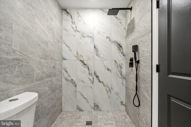 bathroom featuring toilet, tile walls, and a tile shower