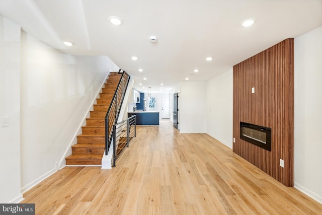 living room featuring a fireplace and light wood-type flooring