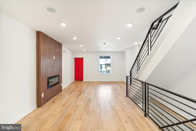 unfurnished living room with light hardwood / wood-style flooring and heating unit