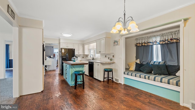 kitchen with butcher block counters, hanging light fixtures, a breakfast bar area, a kitchen island, and white cabinetry