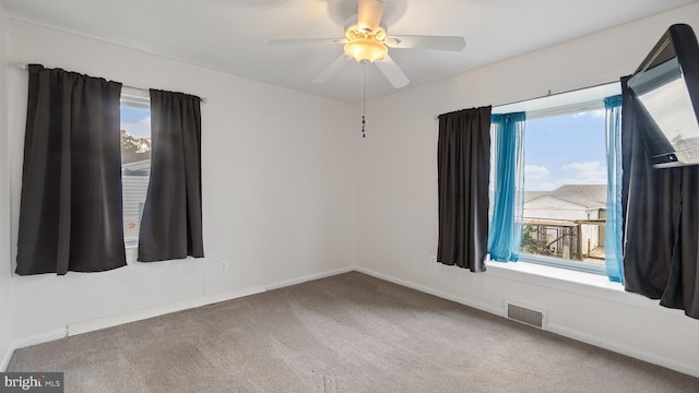 carpeted spare room featuring ceiling fan