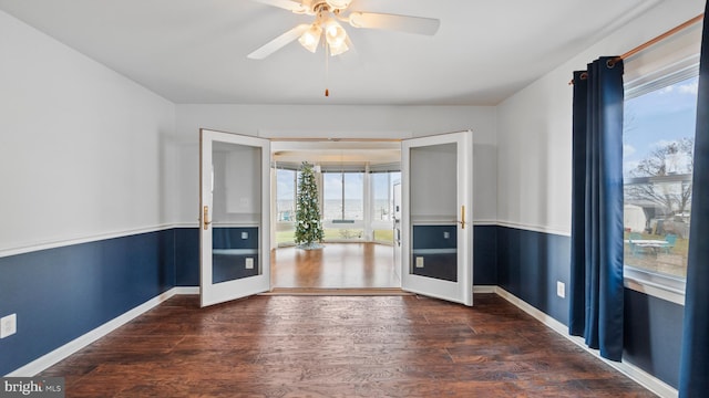 empty room with dark hardwood / wood-style flooring, ceiling fan, a healthy amount of sunlight, and french doors