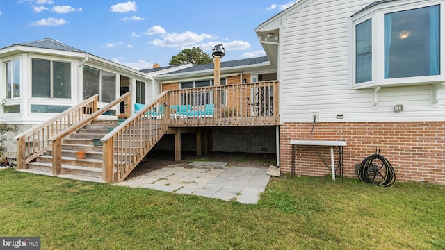 rear view of property with a yard, a patio, a sunroom, and a deck