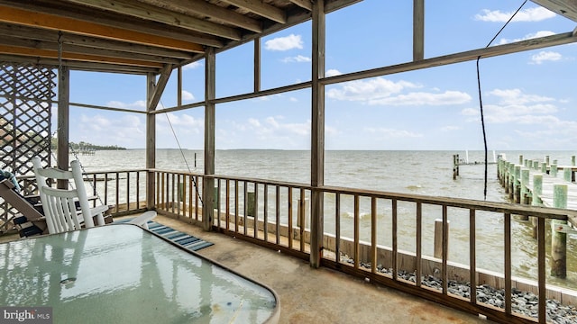 unfurnished sunroom featuring a water view