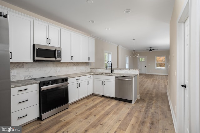 kitchen with white cabinetry, a wealth of natural light, light hardwood / wood-style floors, and stainless steel appliances