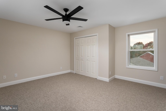 unfurnished bedroom featuring a closet, carpet flooring, and ceiling fan