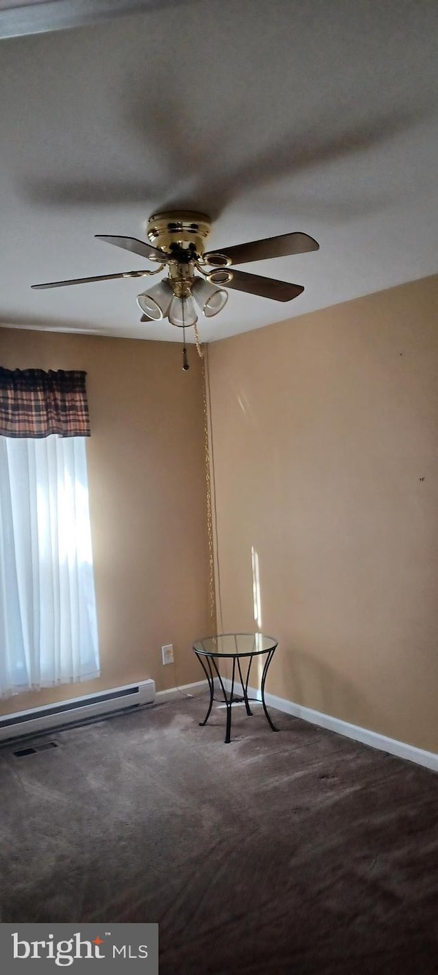 interior space with ceiling fan, carpet floors, and a baseboard heating unit