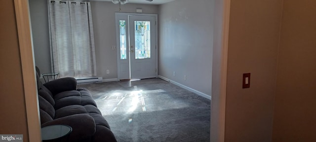 interior space with a baseboard radiator, ceiling fan, and dark carpet