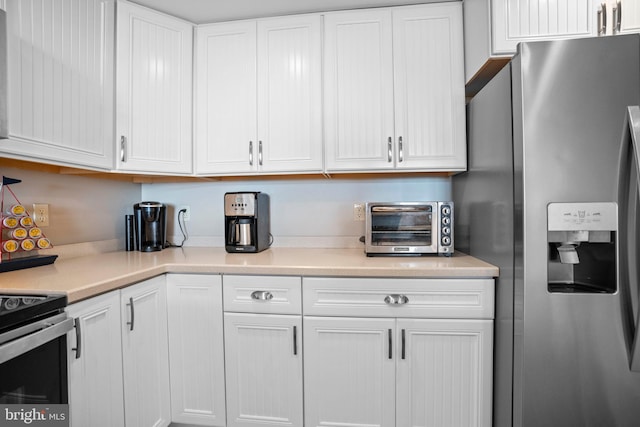 kitchen with white cabinets and stainless steel fridge