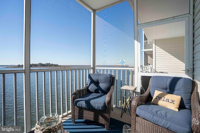 sunroom / solarium featuring a water view