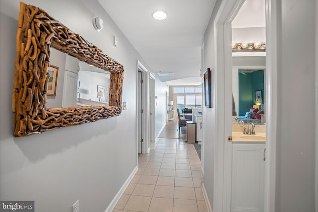 hallway with light tile patterned floors and sink