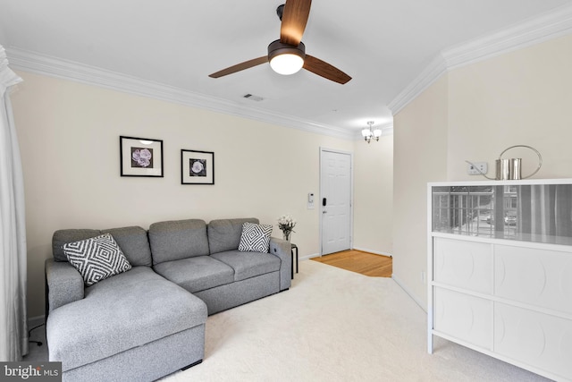 living room with carpet flooring, ceiling fan with notable chandelier, and ornamental molding