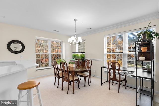 dining space with a chandelier, light colored carpet, and crown molding