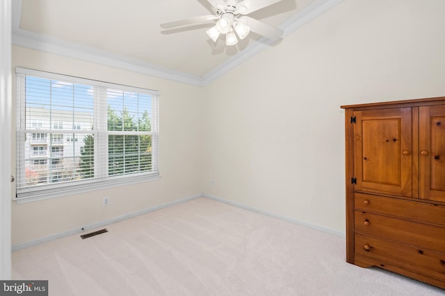 empty room with ornamental molding, light colored carpet, and lofted ceiling