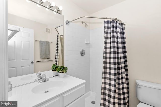 bathroom with toilet, curtained shower, and sink