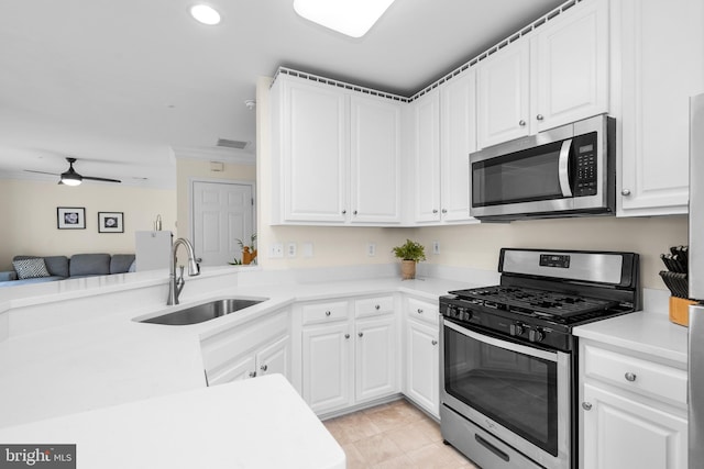 kitchen featuring sink, kitchen peninsula, ceiling fan, white cabinetry, and stainless steel appliances