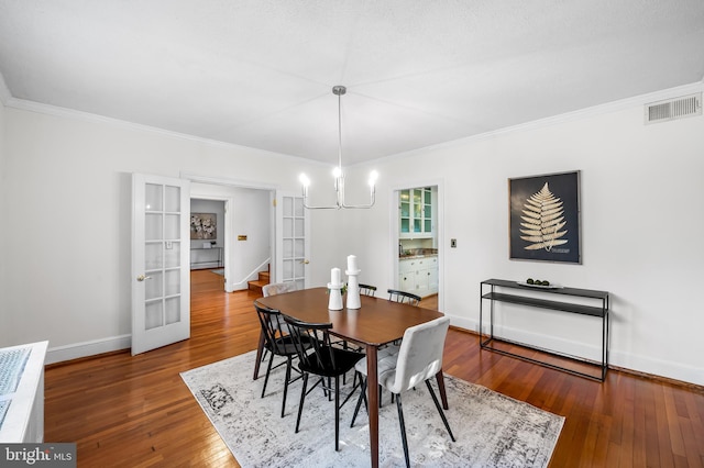 dining space featuring visible vents, french doors, baseboards, and hardwood / wood-style flooring