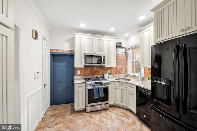 kitchen featuring black appliances, crown molding, backsplash, and a sink