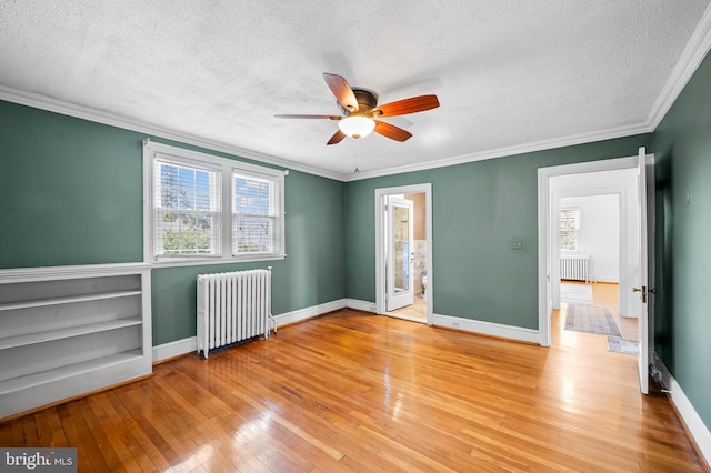 unfurnished bedroom with crown molding, radiator, baseboards, and light wood finished floors