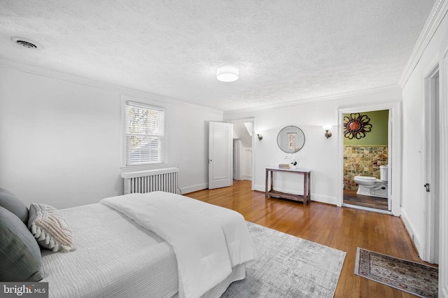 bedroom featuring visible vents, a textured ceiling, crown molding, and hardwood / wood-style flooring