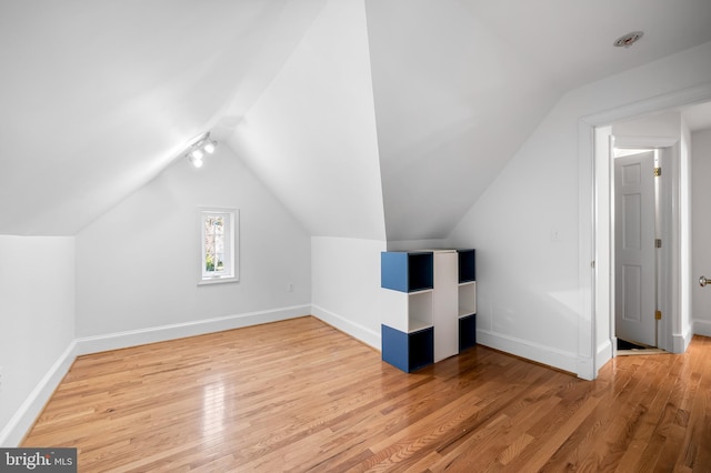 bonus room with lofted ceiling, baseboards, and hardwood / wood-style floors