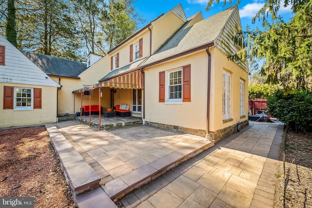 rear view of house featuring stucco siding, a patio, roof with shingles, and fence